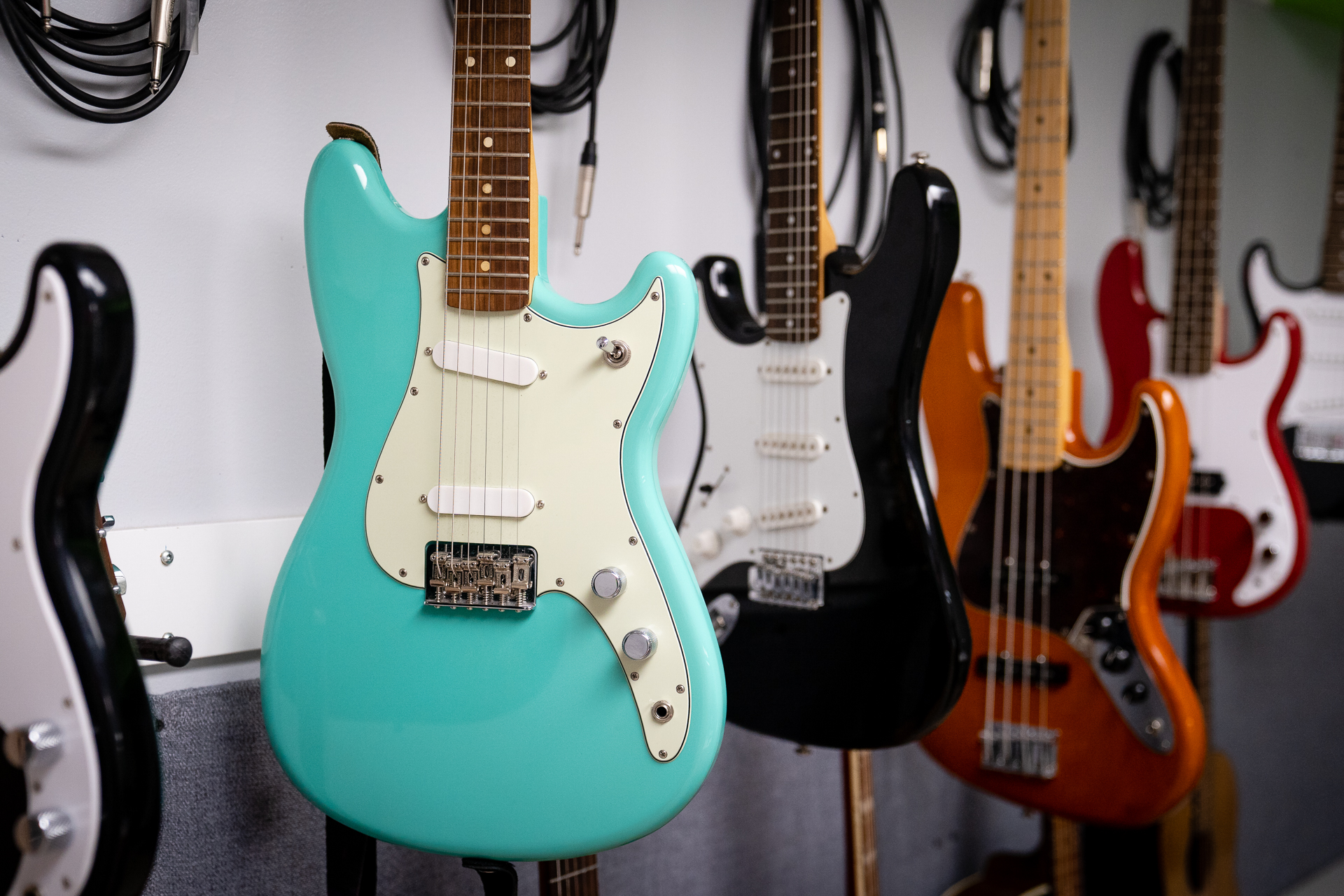 A wall of brightly coloured guitars hang in the music studio at Teen Stop Jeunesse